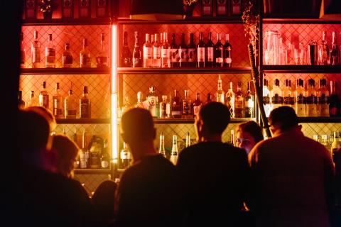 people sitting inside a darkly lit bar