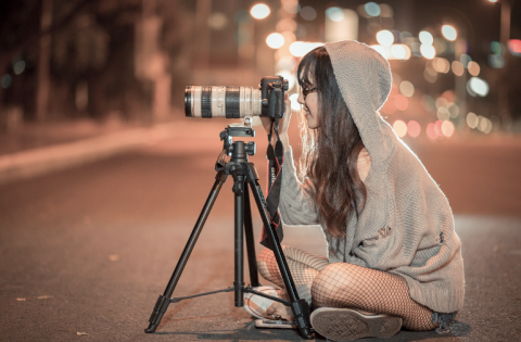 woman taking a photo with a long lens camera